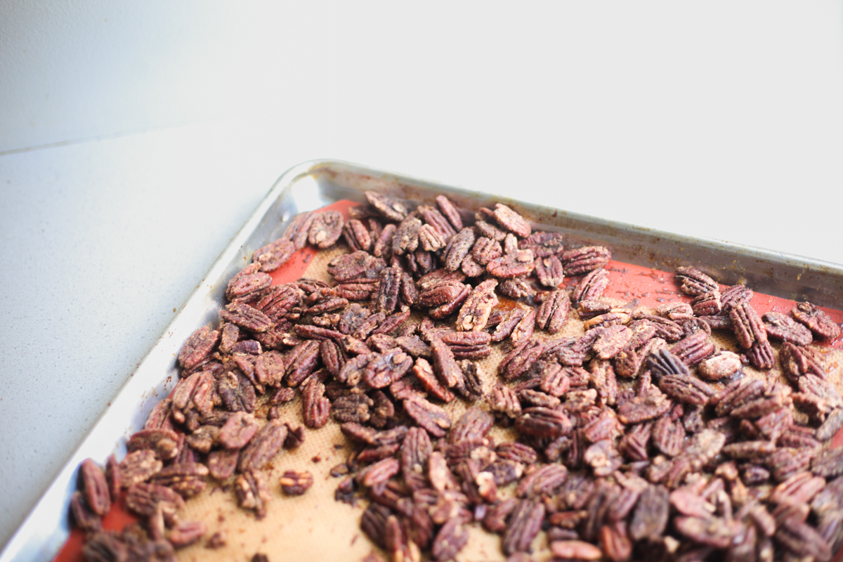 Baking tray covered with freshly roasted dark brown pecans