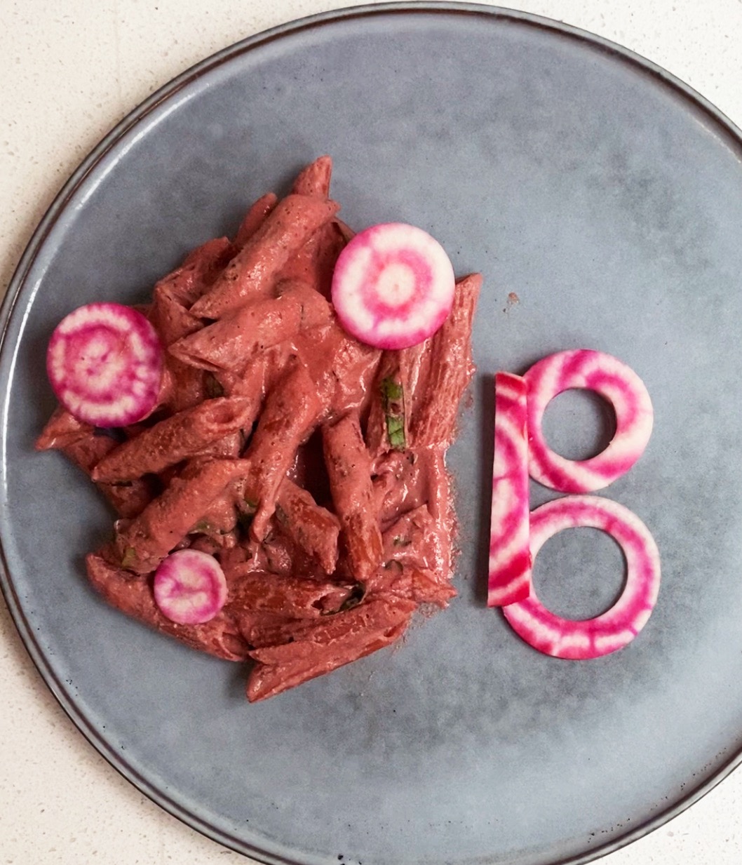 pink pasta with a beet cut into a B shape